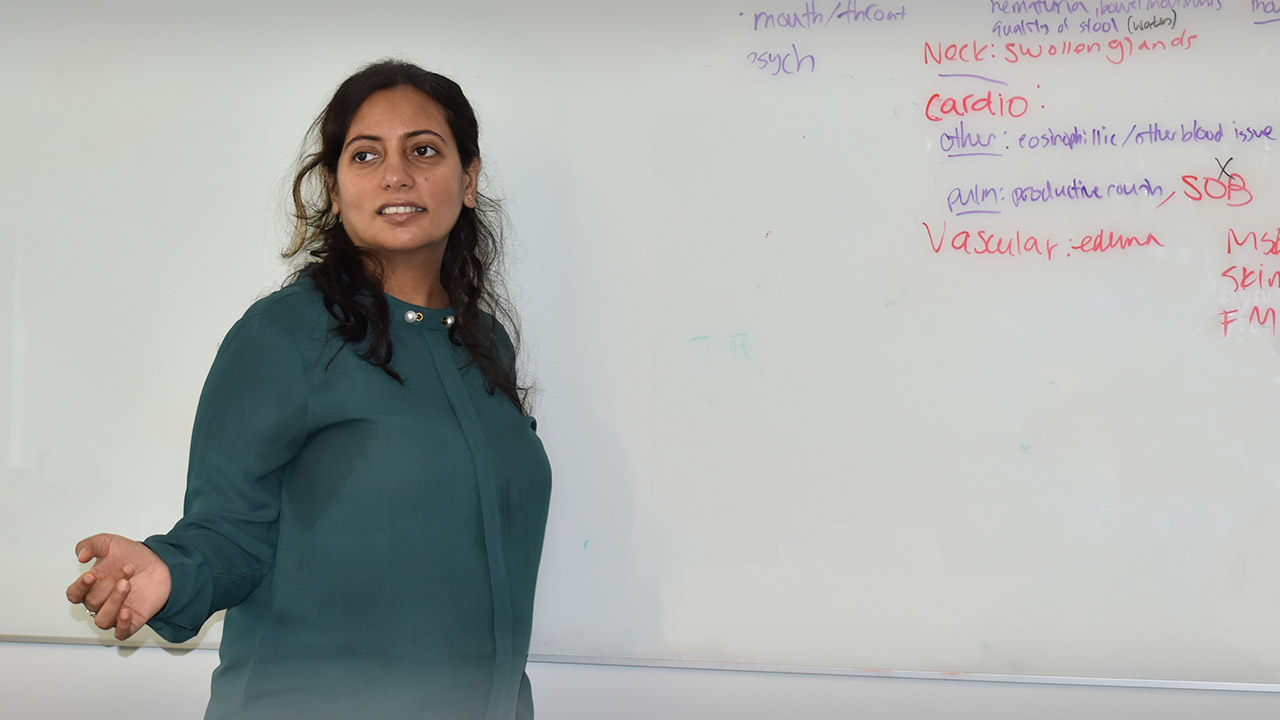 View of Praachi Priya standing in front of a white board