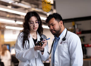 Two Texas A&M students tinker with a medical device.