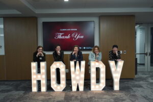 Faculty in from of HOWDY sign