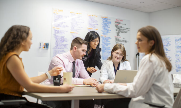 EnMed Students in Conversation at work table