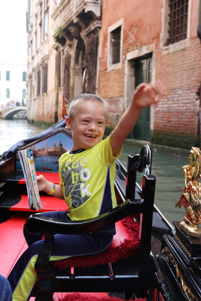 Leo Erquiaga smiling and waving in a gondola in Venice, Italy