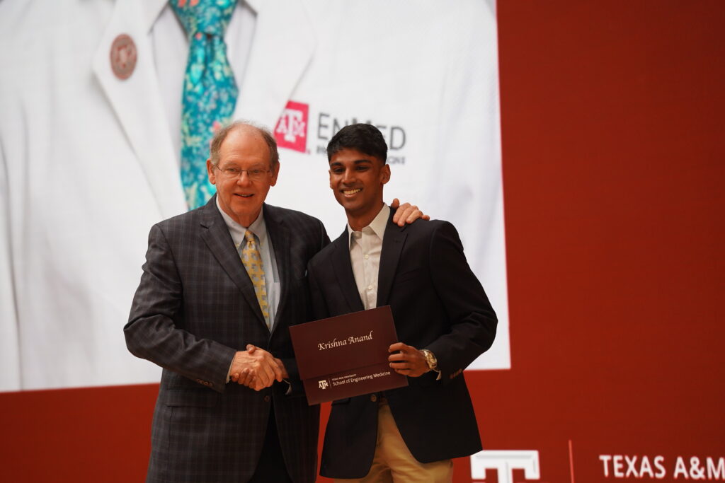 EnMed student Krishna Anand shakes hand of the Dean as he recieves his match on Match Day